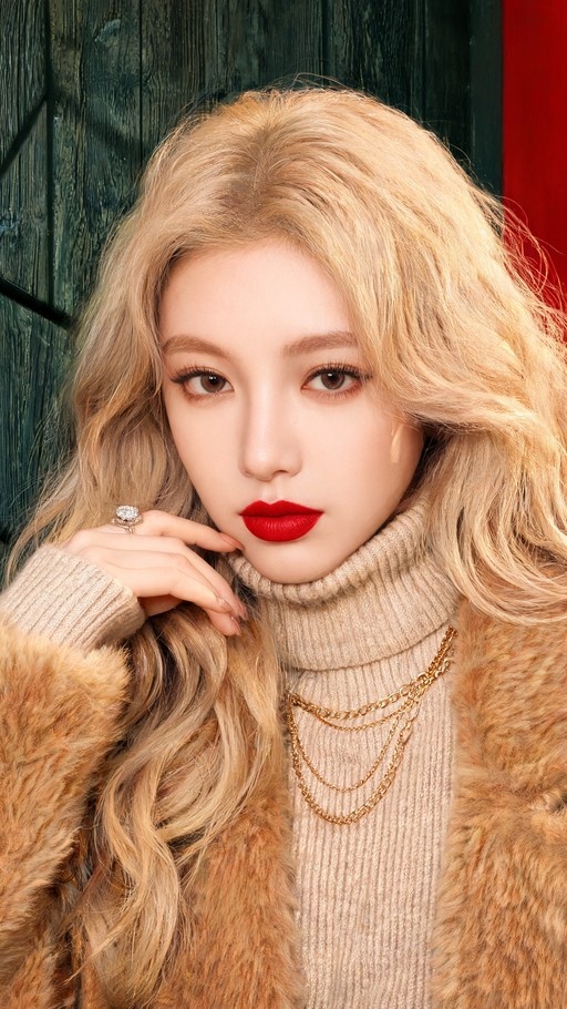 Portrait of a blonde woman with red lips wearing a brown fur coat and beige turtleneck