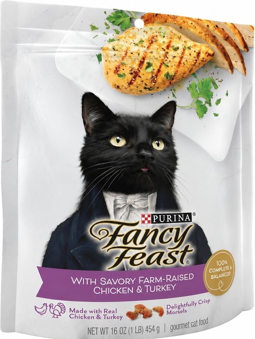 A Purina Fancy Feast cat food pouch featuring a black cat in a tuxedo looking up at sliced grilled chicken.