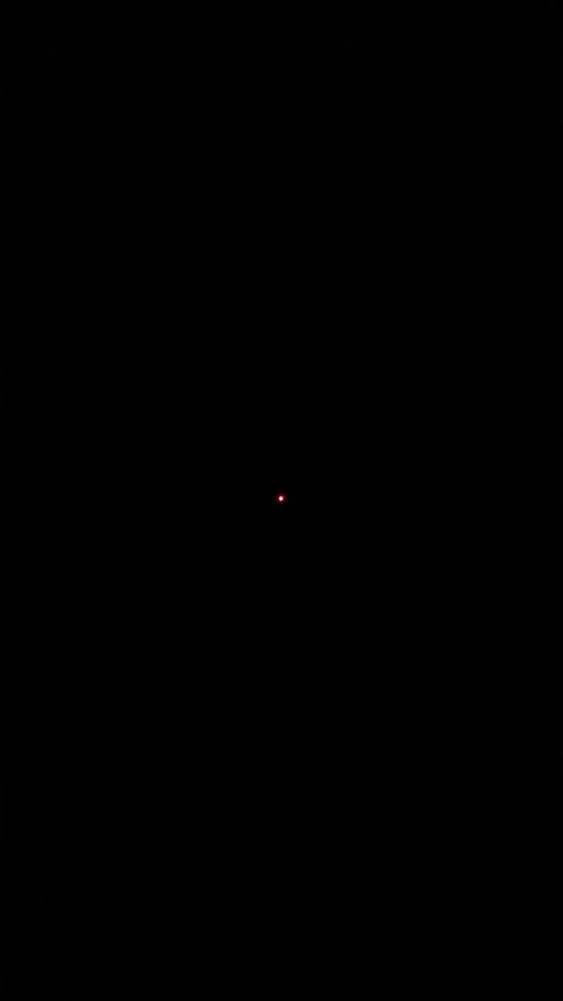 Rumia from Touhou Project with glowing red eyes and a spiral design looking at the viewer against a black background.