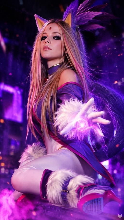 Avril Lavigne cosplaying as Blaze the Cat in a purple outfit with fox ears and tail, kneeling while holding a glowing purple orb of energy in her hand.